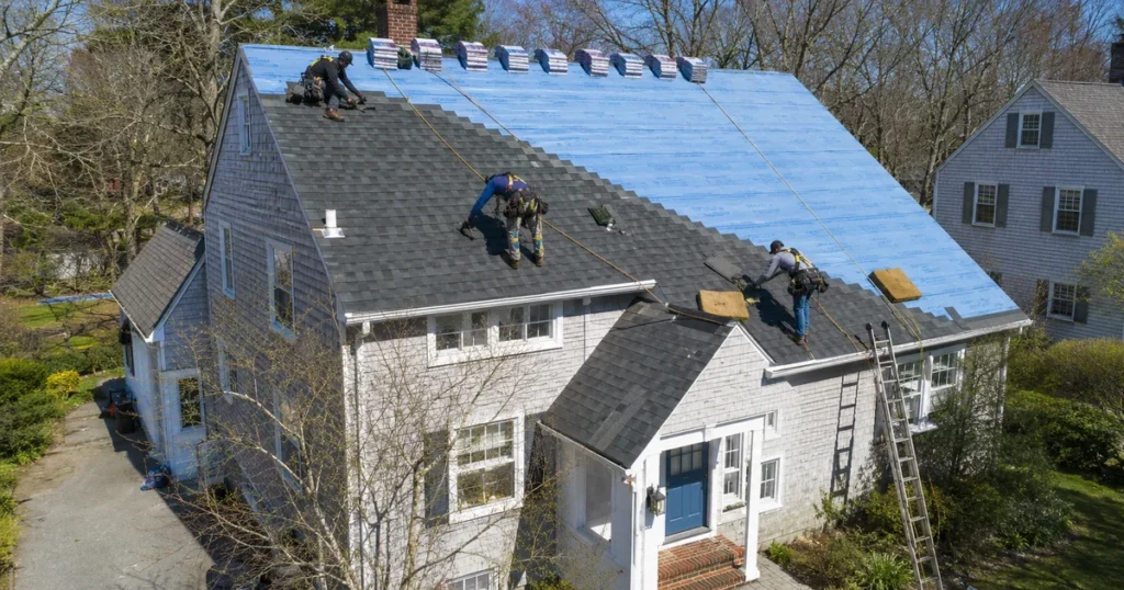 Powersol Roofing crew installing GAF shingles on a Massachusetts home