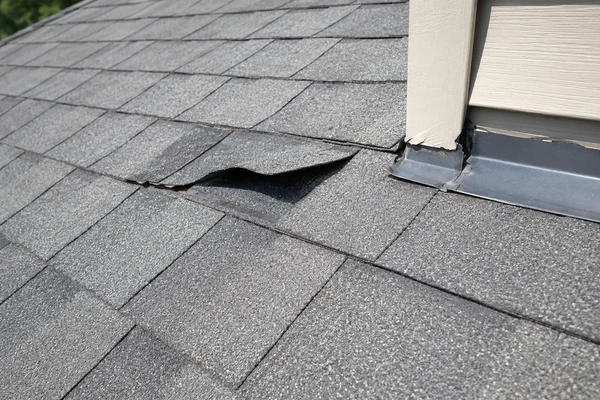 Lifted asphalt shingles after wind, a repairable roof problem
