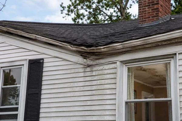 sagging roofline and interior ceiling stain from a roof leak