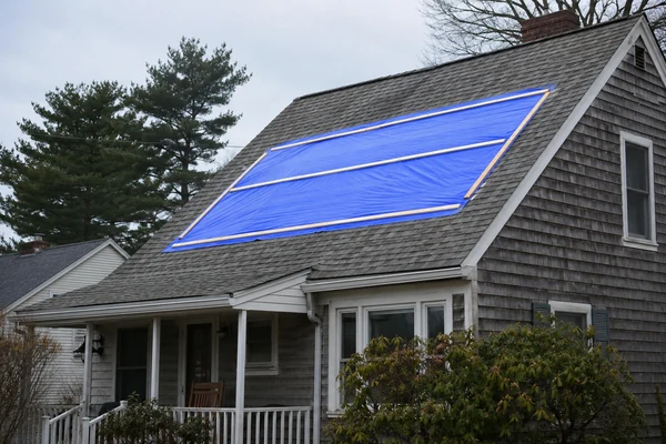 Properly installed emergency roof tarp on a South Shore home