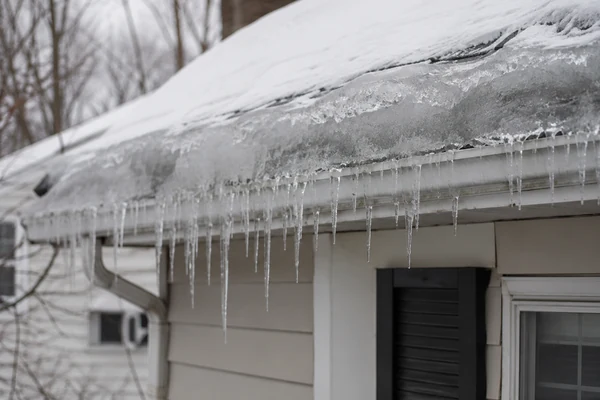 Ice dam at the roof eaves of a Massachusetts home in winter