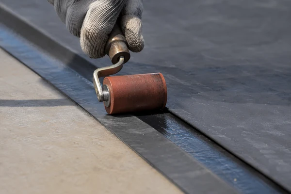 Close-up of a primed and rolled EPDM flat roof seam