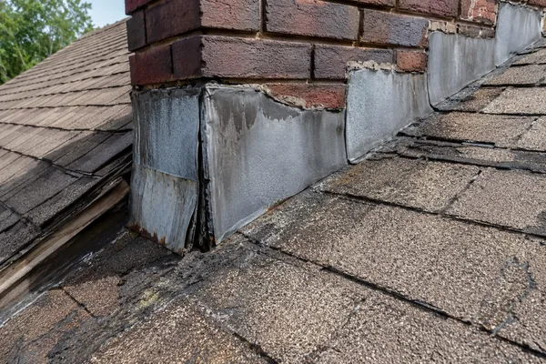 Worn chimney flashing that caused a roof leak, not the shingles