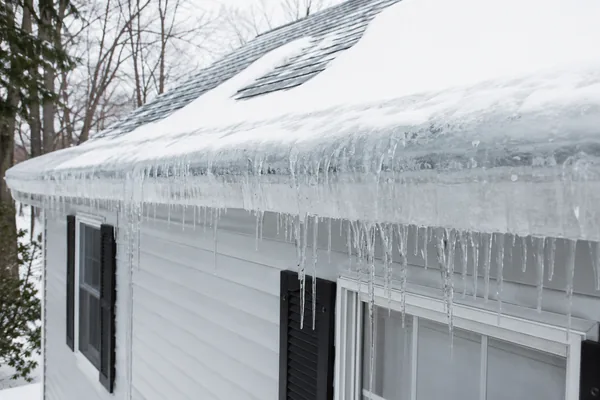 Ice dam on a Massachusetts roof eave causing a leak