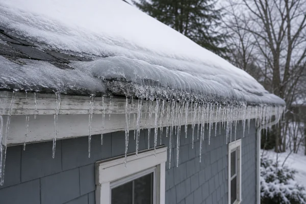 ice dam forming along the eave of a snowy roof